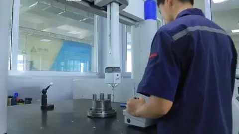 Technician measuring a gear component on a coordinate measuring machine