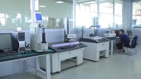 Inspection laboratory with coordinate measuring equipment and a technician at a bench