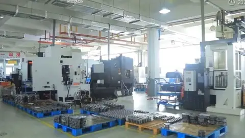 Wide view of a machining hall with CNC equipment and palletised component housings